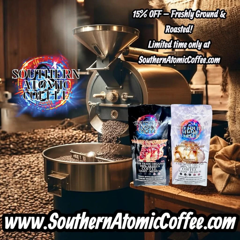 Two Southern Atomic Coffee bags lie on a table next to large commercial coffee roasters. Coffee beans are scattered on the ground around the table, showing the roasting environment.